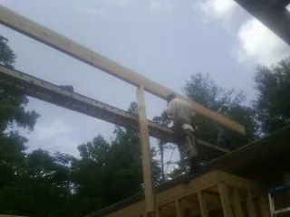 Carpenter setting a ridge beam over a new addition frame — Ice Dam Removal by Roofing Brothers in Shasta